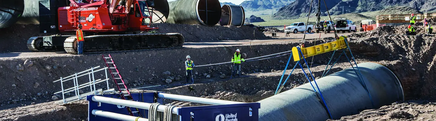 Trench safety workers in trench on large pipe