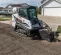 White and black BOBCAT Compact Track Loader digging dirt