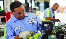 two men working on equipment with gloves
