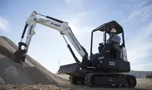 man in mini excavator near dirt pile