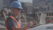 Worker with laptop on jobsite