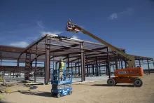 Workers using lifts at a job site