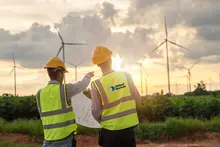 two men in safety vests on wind farm